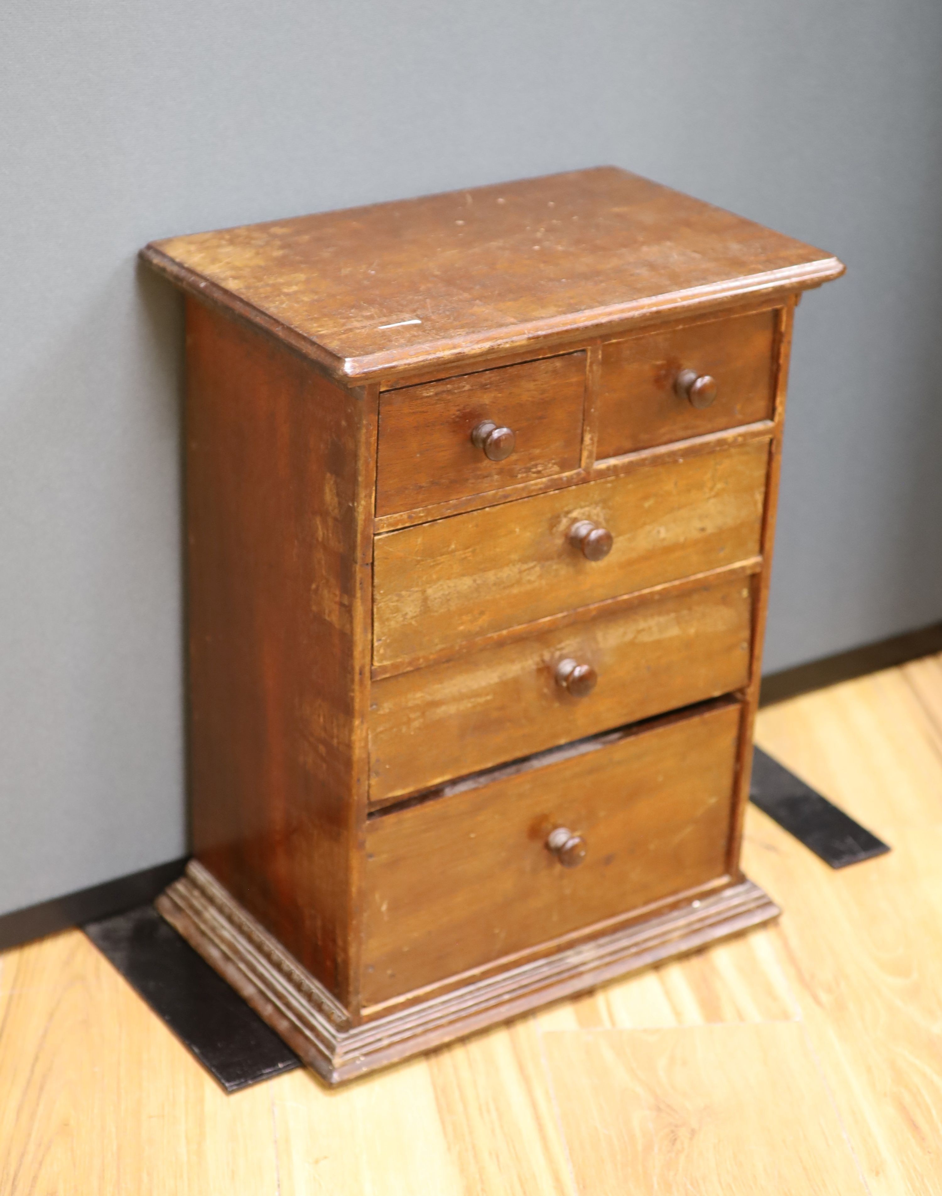 An early 20th century miniature chest and contents